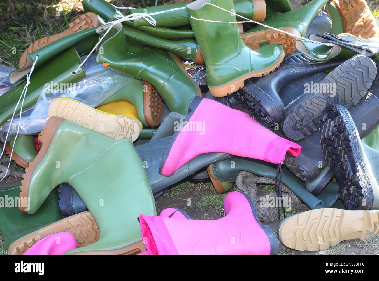 pile of many rubber boots for sale in used and new goods store Stock