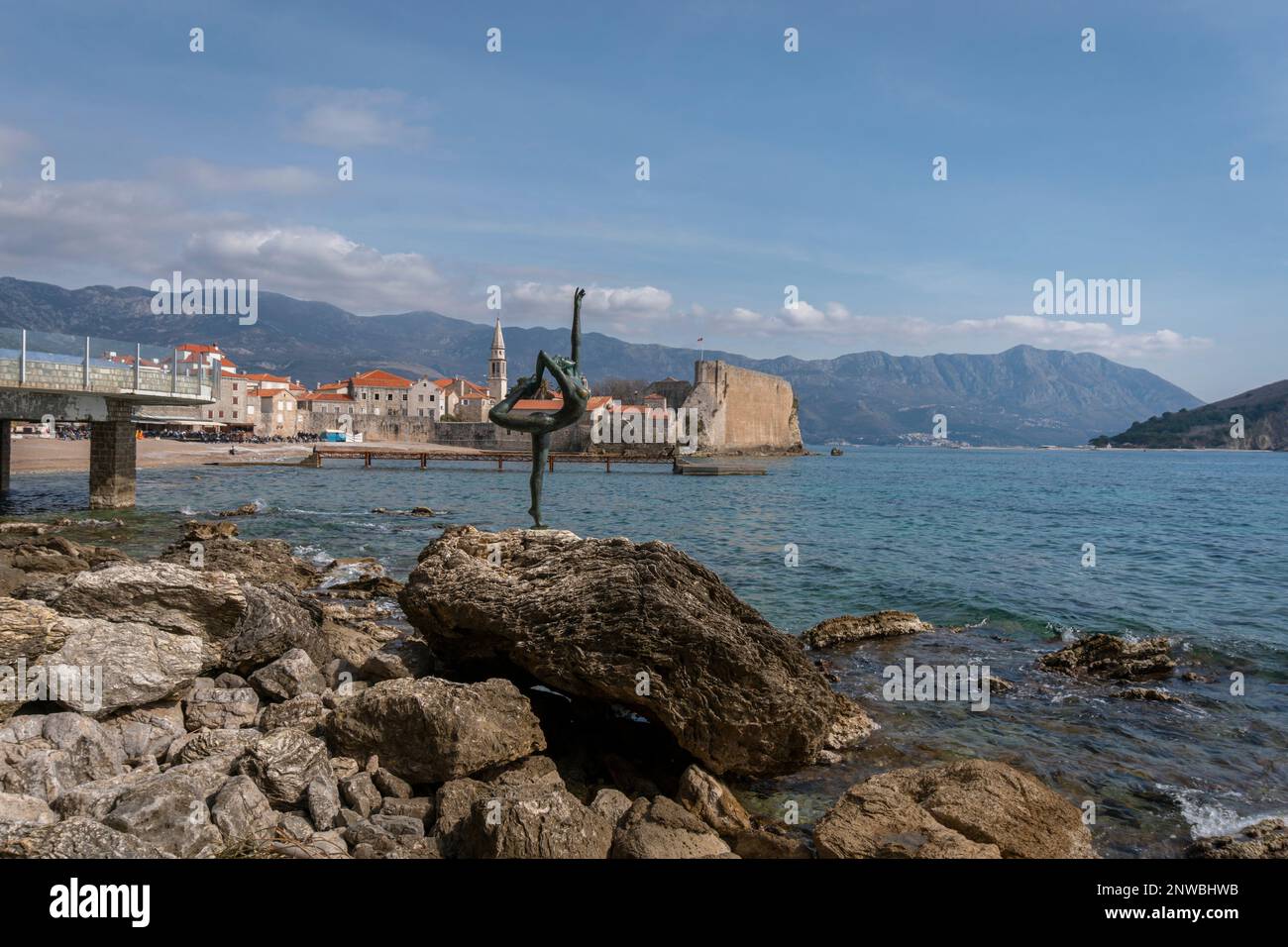 Sculpture of Ballerina Dancer of Budva by artist Gradimir Alexits, with the old town of Budva in the distance, Montenegro Stock Photo