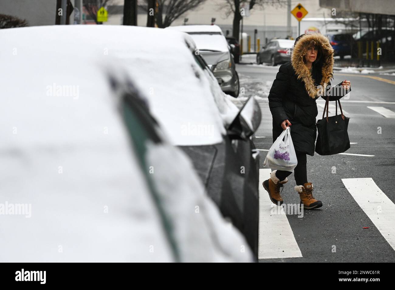 New York, USA. 28th Feb, 2023. A woman in a winter coat crosses the ...