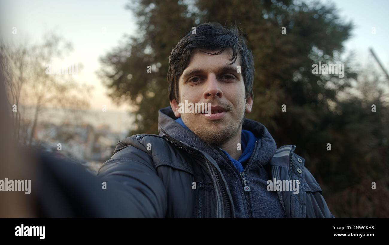 Handsome Young Man with Beautiful Hair Having a Video Call in Pov View Against Sunset Sky and Trees Background Stock Photo