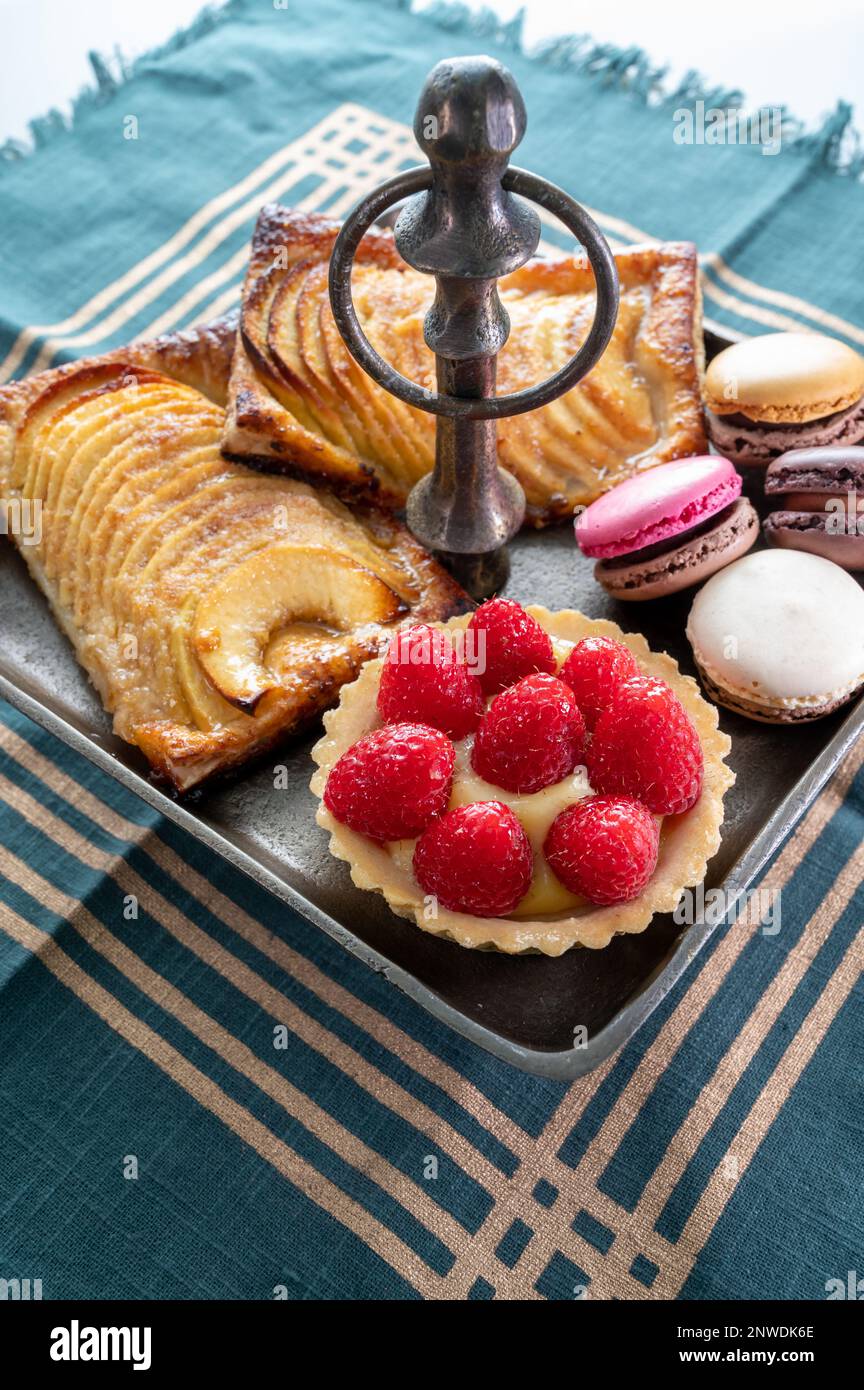 High tea with sweet baked tart with ripe red raspberry, apple cake with ...