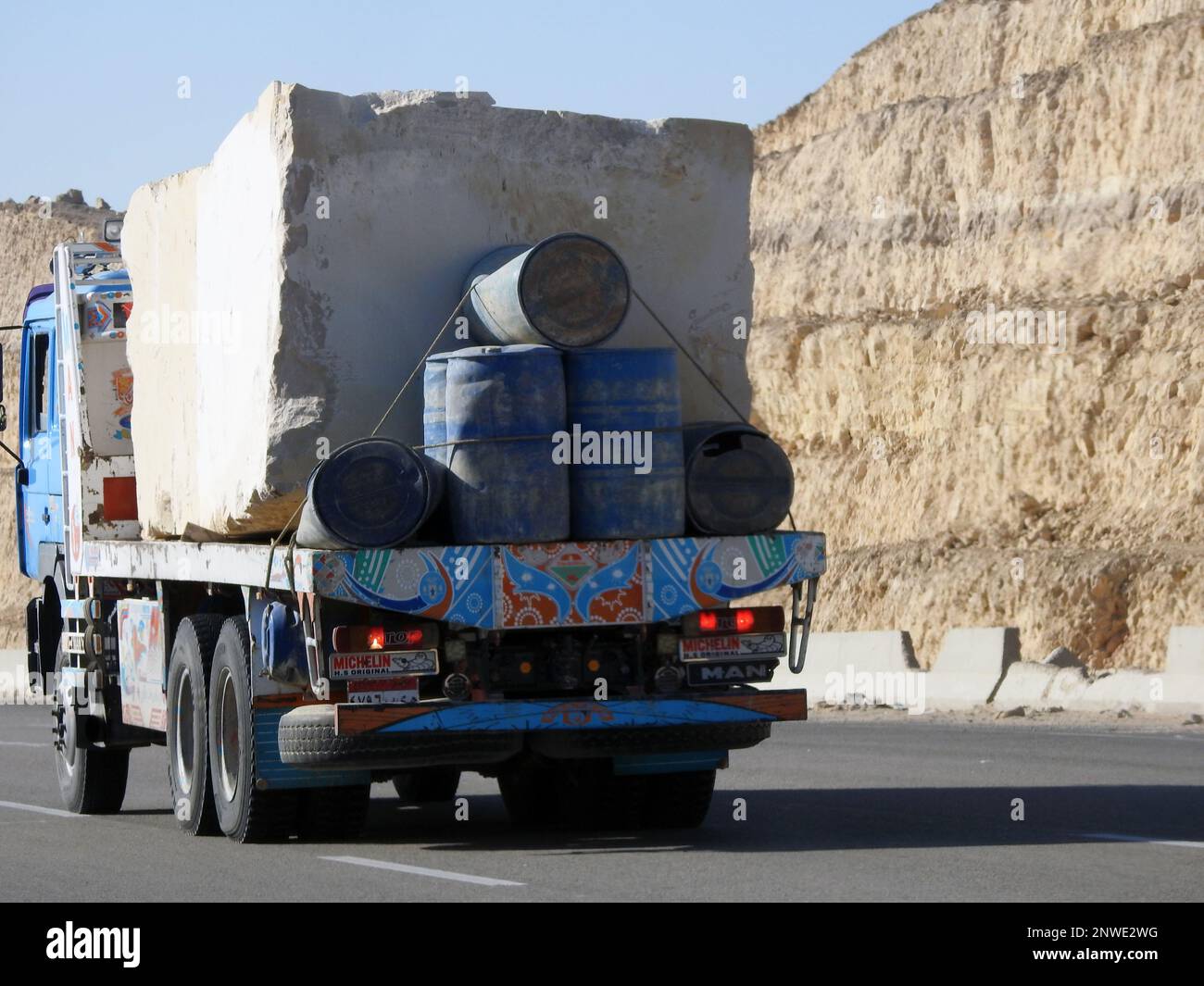 Giza, Egypt, January 26 2023: A big truck loaded with large blocks of stone, limestone, rocks taken from quarries in mountains being transferred on a Stock Photo