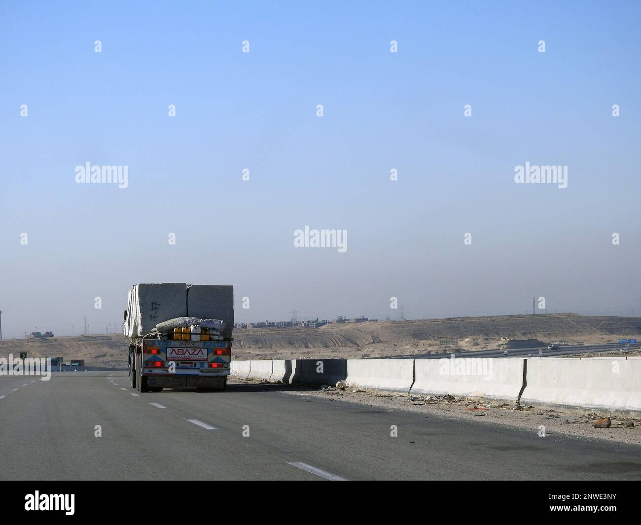 Giza, Egypt, January 26 2023: A big truck loaded with large blocks of stone, limestone, rocks taken from quarries in mountains being transferred on a Stock Photo