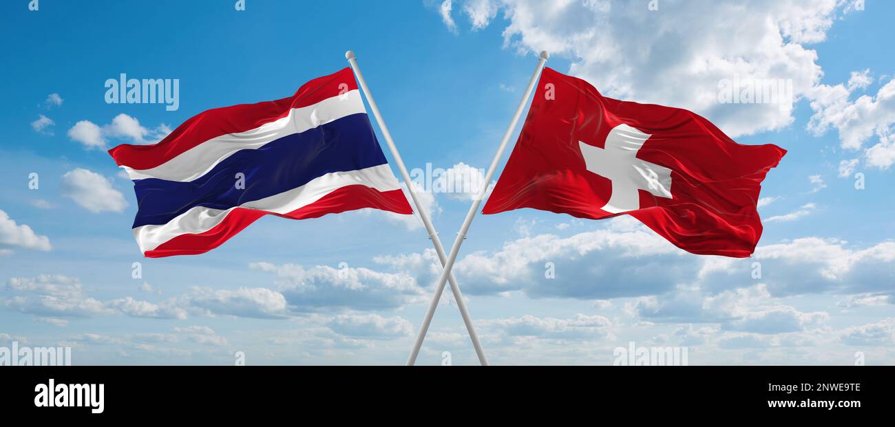 two crossed flags switzerland and Thailand waving in wind at cloudy sky ...