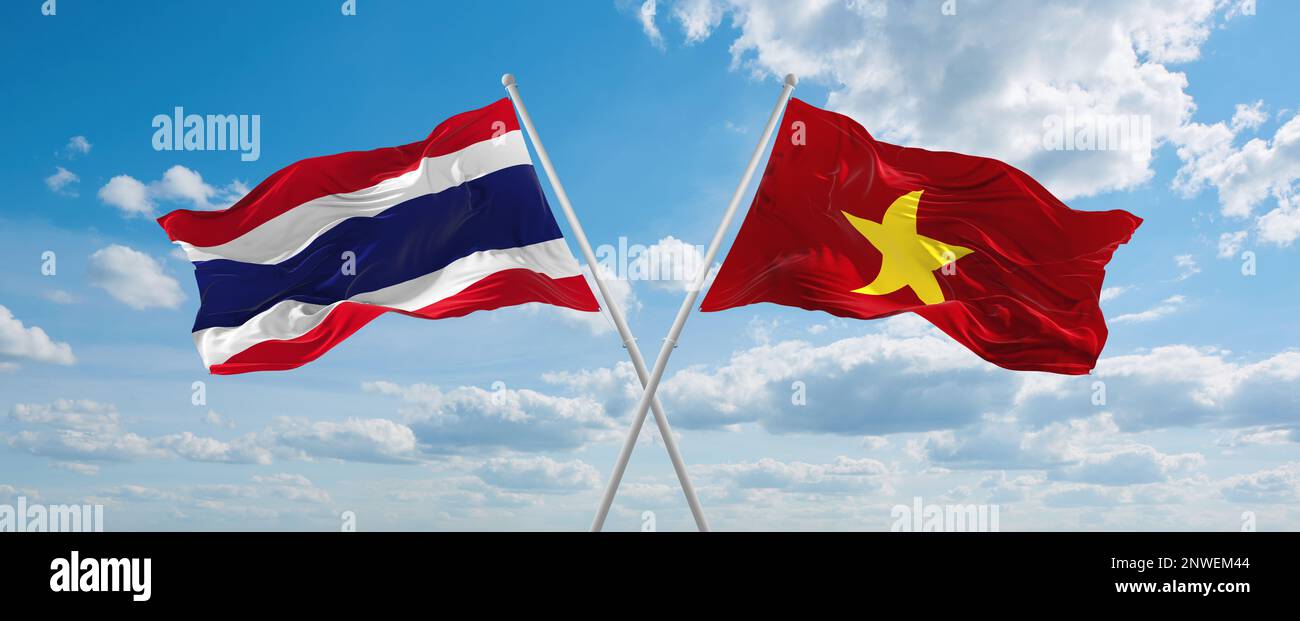 two crossed flags Vietnam and Thailand waving in wind at cloudy sky ...