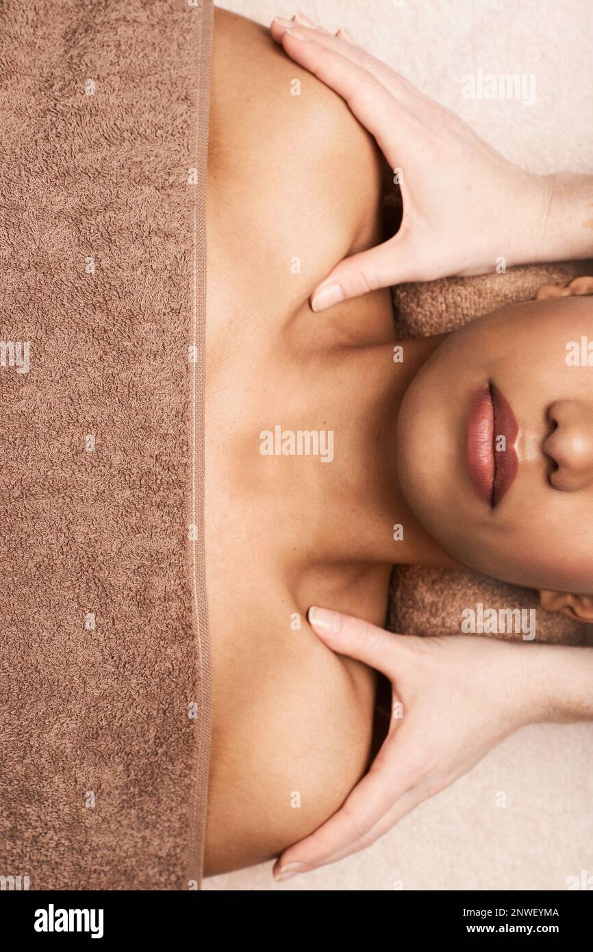 Masseuse massaging chest and shoulders of young woman, view from above Stock Photo