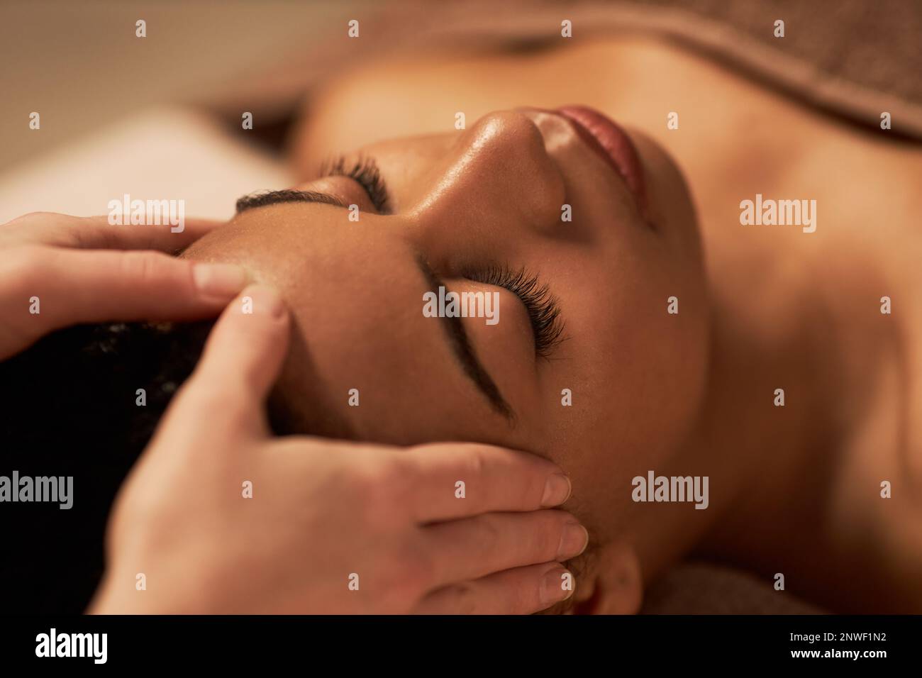 Young woman receiving face massage to get glowing and firm complexion Stock Photo