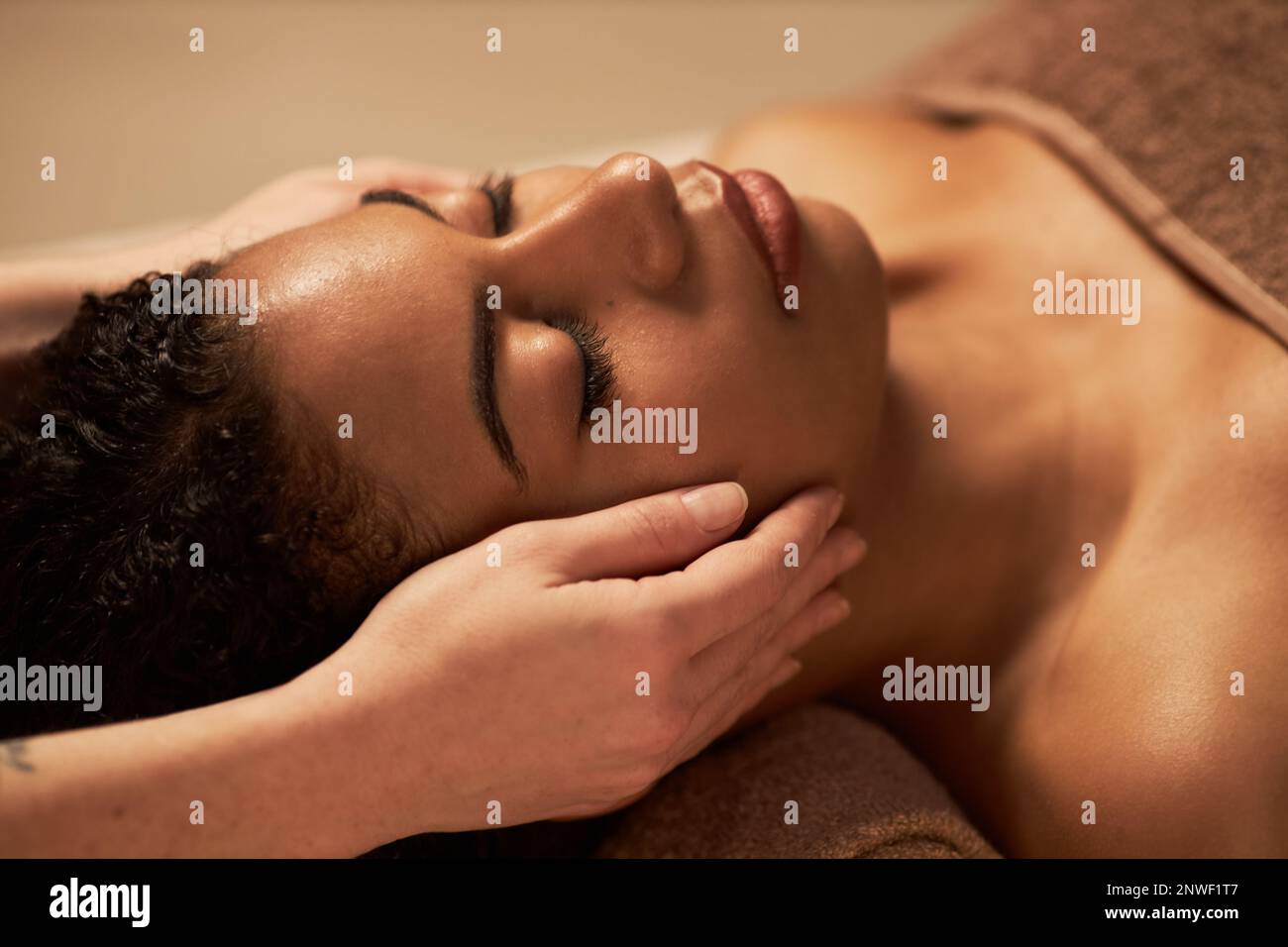Young woman getting rejuvenating face massage in beauty salon Stock Photo