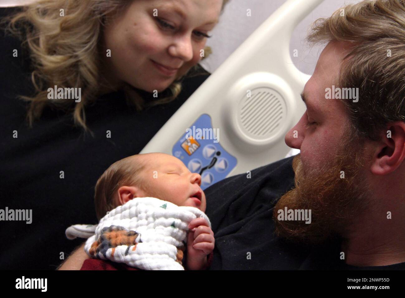 In this Tuesday, Oct. 23, 2018, photo Andrew Goette and his wife, Ashley,  look at their baby, Lennon, at United Hospital in Saint Paul, Minn. Andrew  awoke from a medically-induced coma just