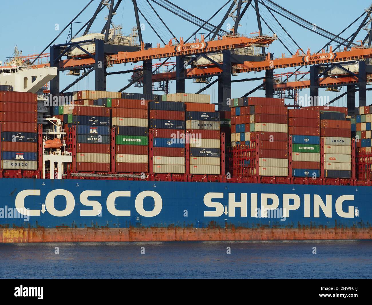 Detail of a Cosco shipping container ship at the terminal of the Port of Rotterdam, the Netherlands. Stock Photo