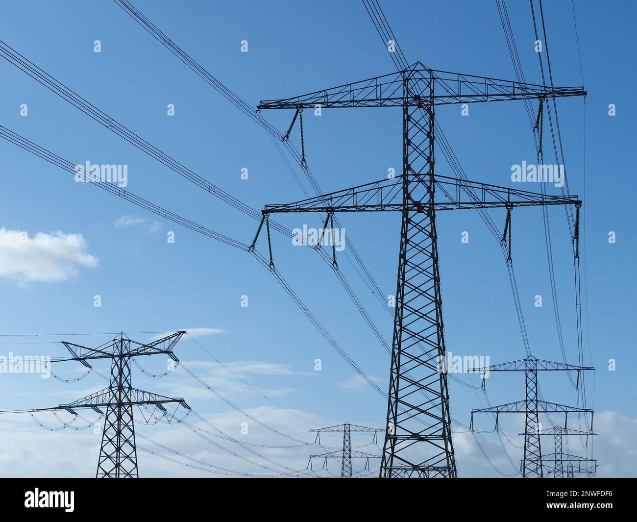 many high voltage power electicity lines masts towers in the port area