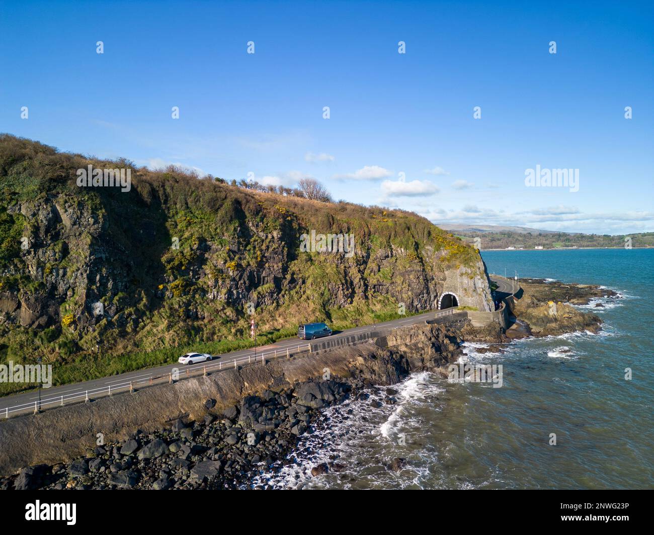 Aerial images of from various locations in and around Larne, County Antrim, Northern Ireland. In this photo, this is the  A2 causeway coastal route coast road which passes through the black arch blackcave tunnel as you leave Larne heading further North. Stock Photo