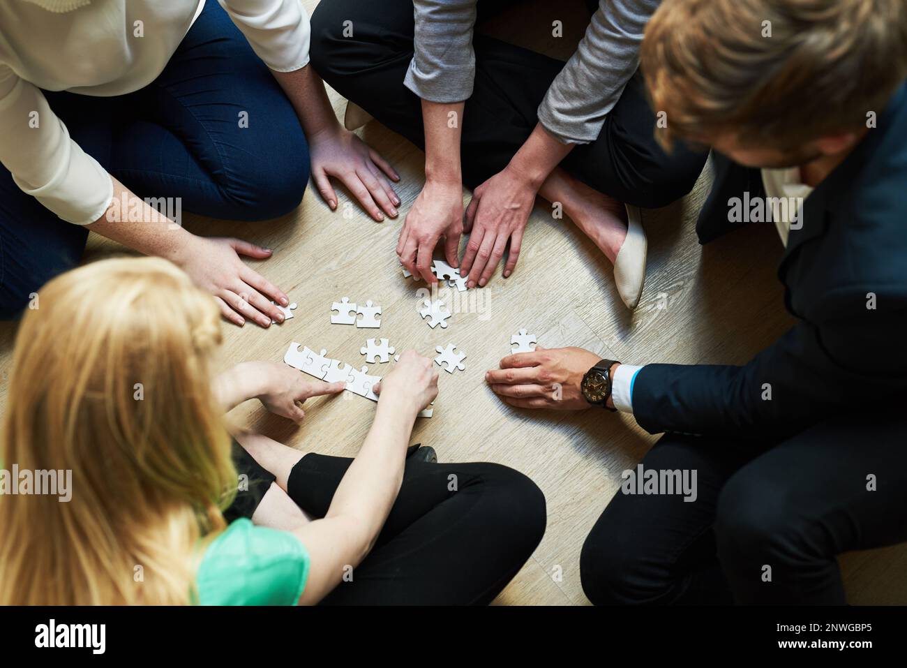 Piecing it together. Shot of a group of people putting a puzzle
