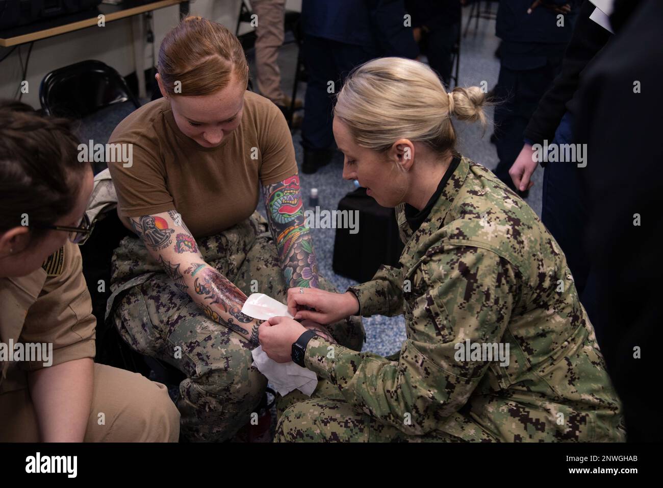 Lt. Cmdr. Susan Murphy, from Modesto, Calif., the first-in-class aircraft carrier USS Gerald R. Ford’s (CVN 78) ship’s nurse, applies a fake bruising wound to Hospital Corpsman 3rd Class Abigail Riddle, from Woodruff, S.C., assigned to Ford's medical department, during moulage application training, Jan. 25, 2023. Moulage is the art of applying mock injuries for the purpose of training emergency response teams and other medical and military personnel. Ford is in port at Naval Station Norfolk for a continuous planned maintenance availability. Stock Photo