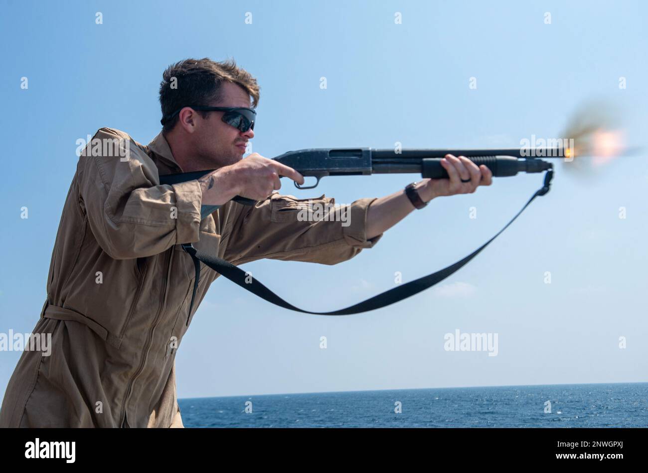 230214-N-NH267-1484 INDIAN OCEAN (Feb. 14, 2023) U.S. Navy Fire Controlman (Aegis) 2nd Class Cody McDonald, from Spring Creek, Nev., fires an M500 shotgun during a visit, board, search, and seizure (VBSS) gun shoot on the flight deck of the Arleigh Burke-class guided-missile destroyer USS Paul Hamilton (DDG 60). Paul Hamilton, part of the Nimitz Carrier Strike Group, is in U.S. 7th Fleet conducting routine operations. 7th Fleet is the U.S. Navy’s largest forward-deployed numbered fleet, and routinely interacts and operates with Allies and partners in preserving a free and open Indo-Pacific reg Stock Photo