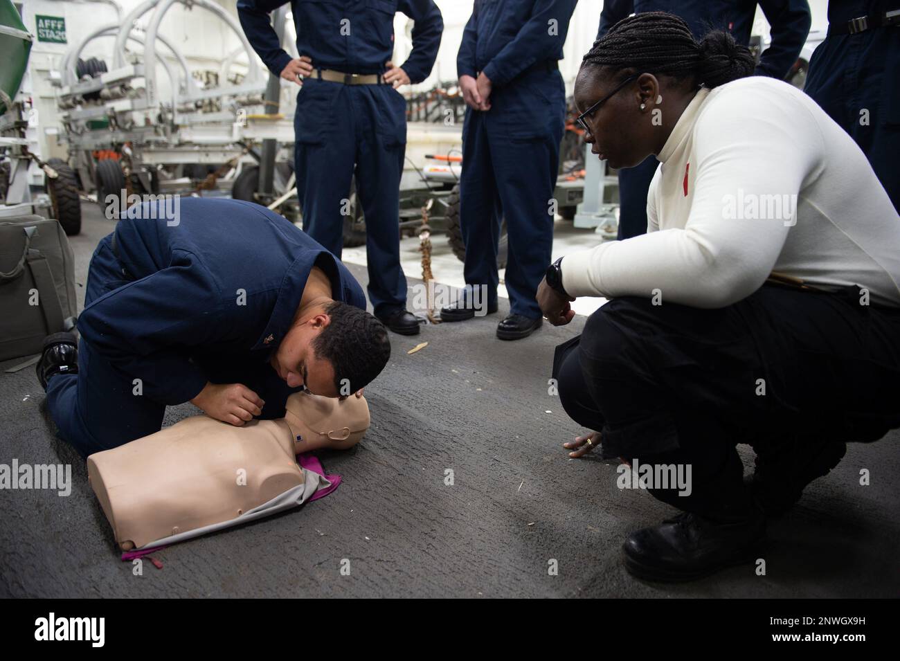 230118-N-MD461-1048 PACIFIC OCEAN (Jan. 18, 2022) Operation Specialist 2nd Class Donta Battle, left, a native of Buffalo, N.Y., checks for breathing during CPR training conducted by Hospital Corpsman 3rd Class Ahmi Atsina, right, a native of New Orleans, La., in the jet shop aboard Nimitz-class aircraft carrier USS Carl Vinson (CVN 70). Vinson is currently underway conducting routine maritime operations. Stock Photo