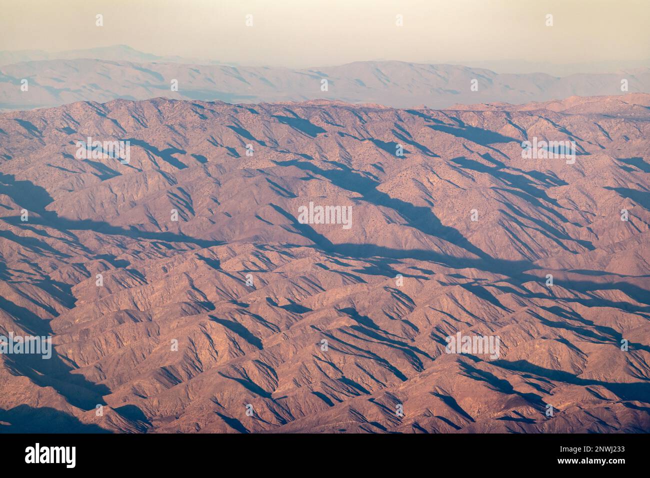 The valley of Palm Springs landscape in fall on a hazy, warm afternoon from aerial, above shot. Stock Photo