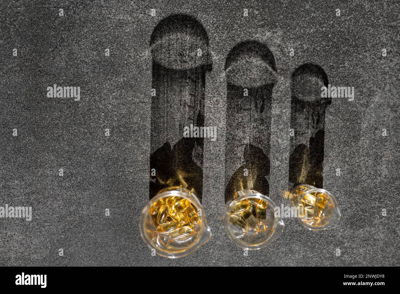 Cod Liver Oil.Fish oil capsules in laboratory flasks on a black slate ...