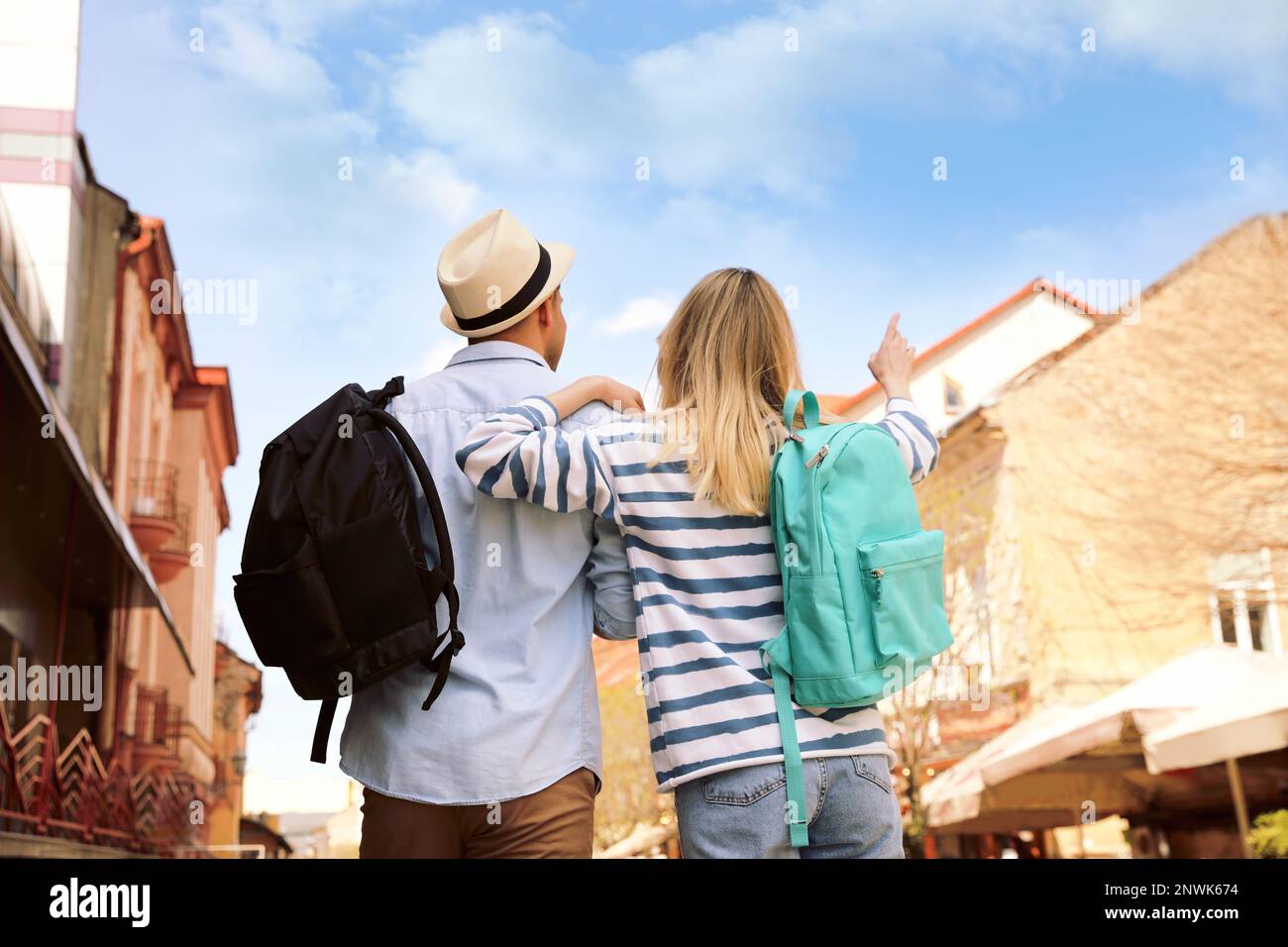 Couple of tourists with backpacks on city street, back view Stock Photo ...