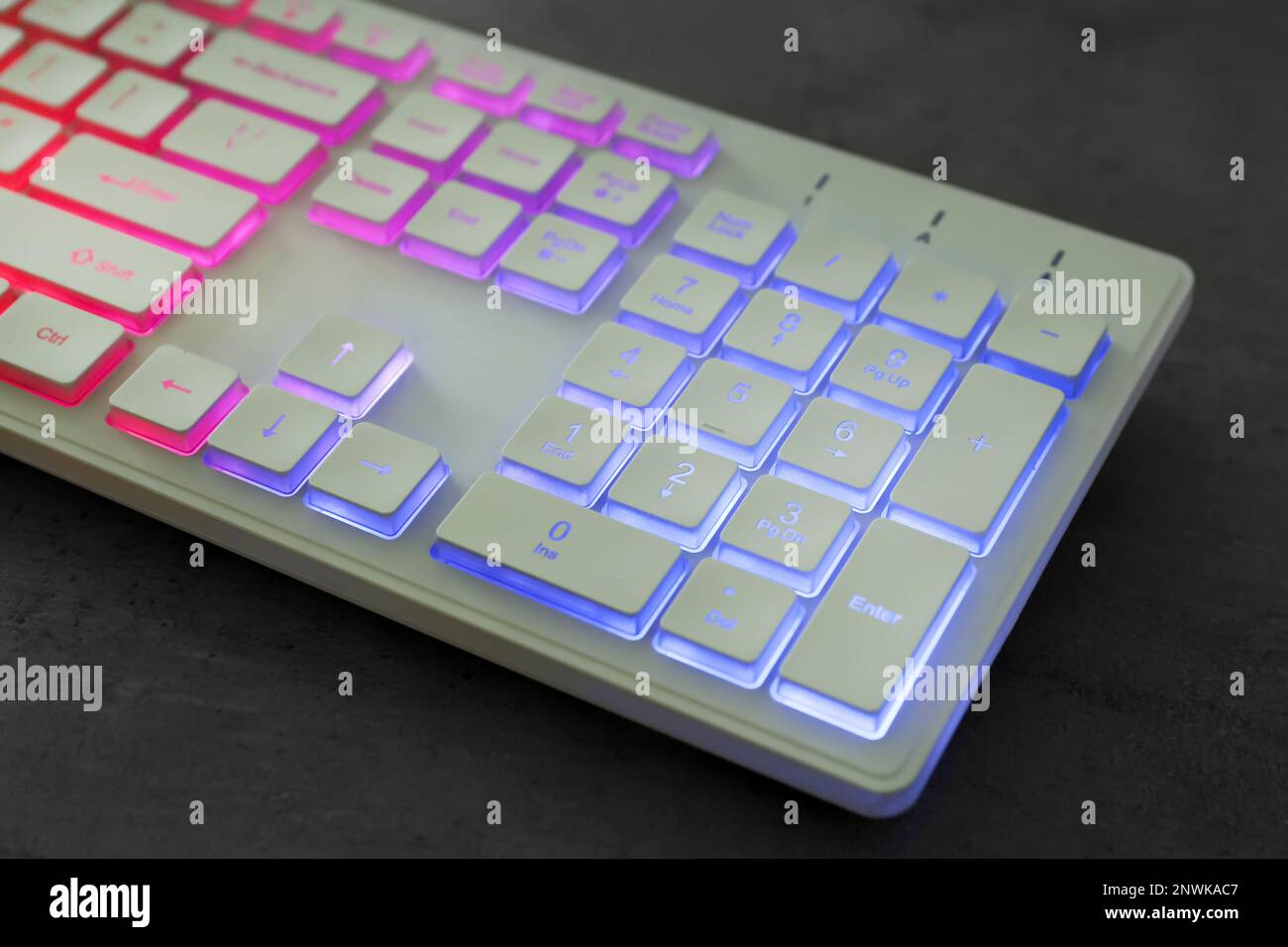 Modern keyboard with RGB lighting on grey table, closeup Stock Photo