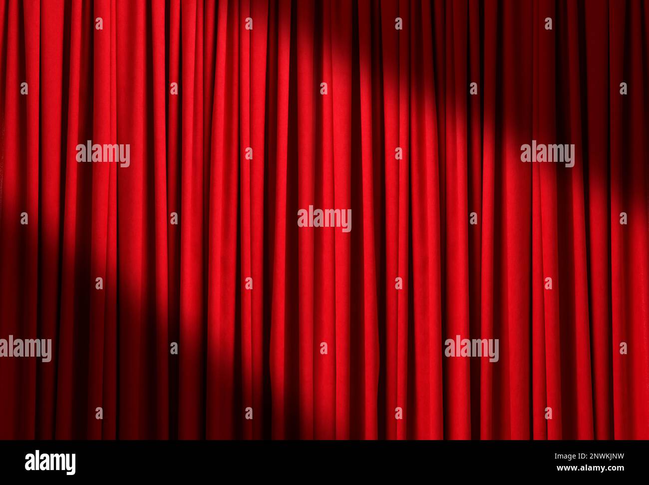 Spotlight illuminating closed red stage curtains. Start of performance Stock Photo