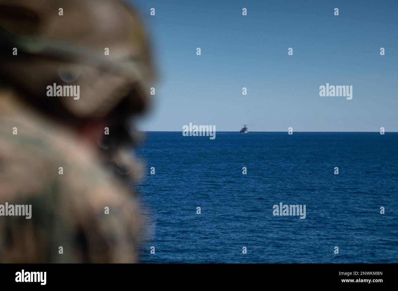 A U.S. Marine with Battalion Landing Team 1/6, 26th Marine Expeditionary Unit, sights in on the Ferry-class dock landing ship USS Carter Hall (LSD 50), during a strait transit exercise part of Amphibious Squadron/MEU Integration Training (PMINT), Jan. 28, 2023. For many Marines and Sailors, this was their first time aboard a warship and their first deployment working alongside the Navy. PMINT serves as an opportunity to strengthen integration between the 26th Marine Expeditionary Unit and Amphibious Squadron Group 8 and train to core mission essential tasks with capabilities organic to a forwa Stock Photo