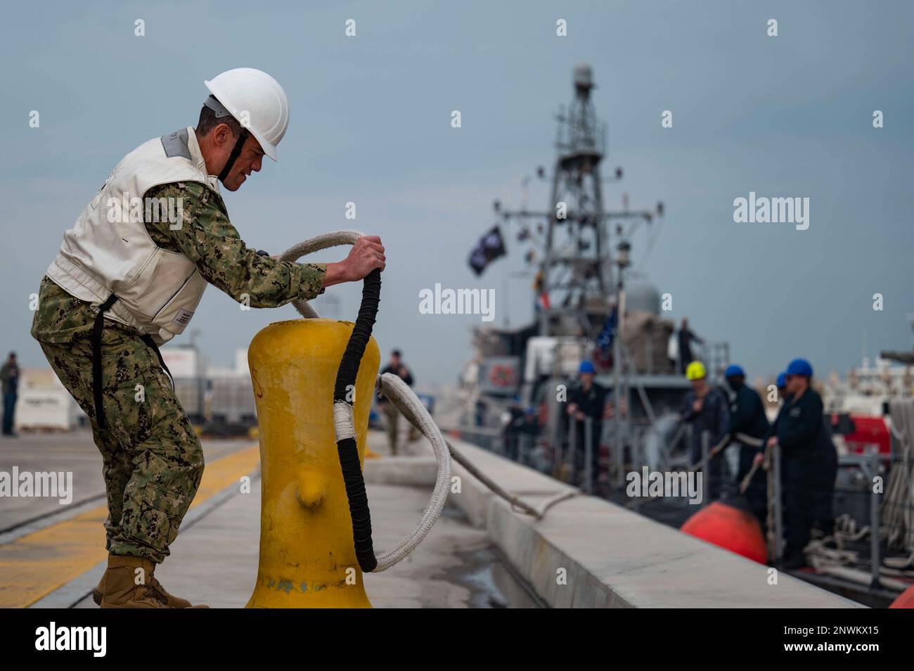 230114-N-EG592-1068 MANAMA, Bahrain (Jan. 14, 2023) Capt. Dave Coles, deputy commander, Destroyer Squadron Fifty, removes a line from a bollard as patrol coastal ship USS Sirocco (PC 6) departs Naval Support Activity Bahrain, Jan. 14. Sirocco is deployed to the U.S. 5th Fleet area of operations to help ensure maritime security and stability in the Middle East region. Stock Photo