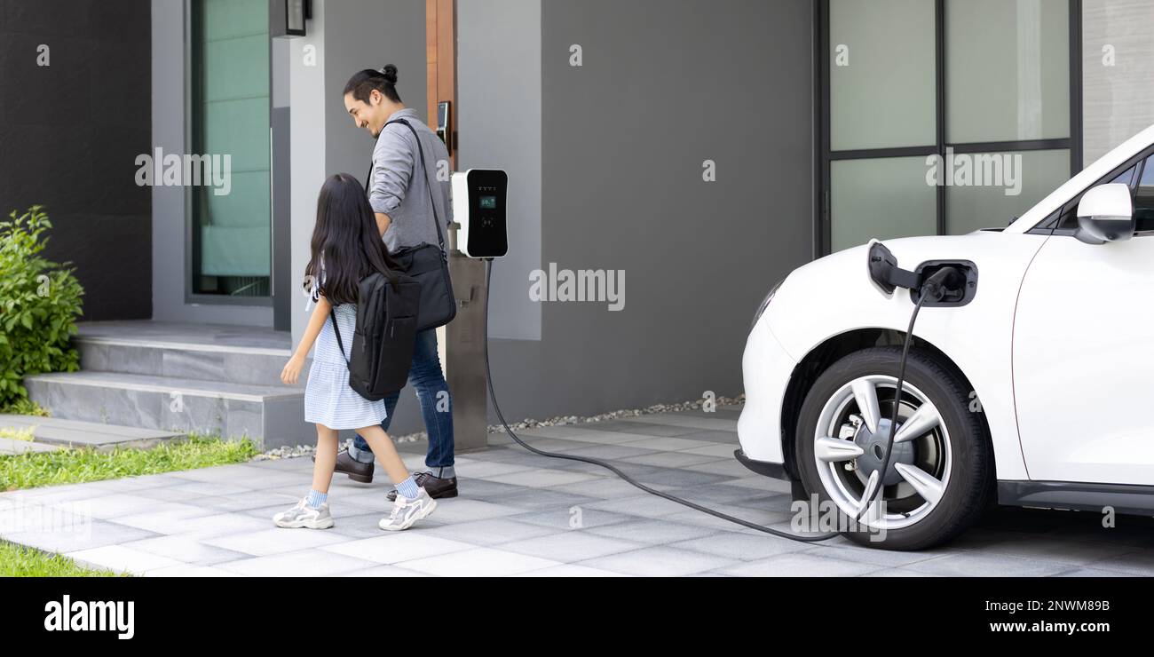 Progressive father and daughter plugs EV charger from home charging