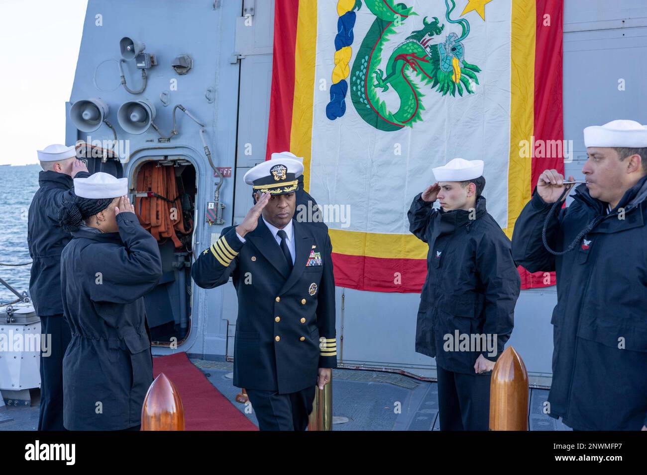 TOKYO BAY, Japan (Jan. 26, 2023) Capt. Walt Mainor, Commodore of Commander Task Force (CTF) 71/Destroyer Squadron (DESRON) 15, salutes Sailors as he walks onto the flight deck of the Arleigh Burke-class guided-missile destroyer USS Ralph Johnson (DDG 114) anchored in Tokyo Bay, Japan, prior to a change of command ceremony, Jan. 26. Ralph Johnson is assigned to CTF71/DESRON 15 forward-deployed to the 7th Fleet area of operation in support of a free and open Indo-Pacific. Stock Photo
