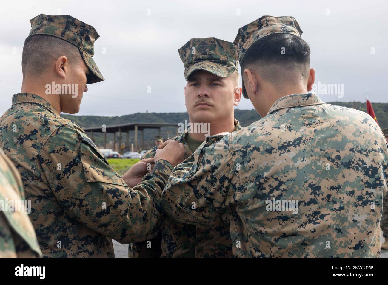 U.S. Marine Corps Lance Cpl. Connor Croghan (center), a water support technician, is meritoriously promoted to the rank of corporal by Staff Sgt. Andre Velez (left), a water support technician, and Cpl. Daniel Long, an electrician, all with Marine Wing Support Squadron (MWSS) 372, Marine Air Control Group 38, 3rd Marine Aircraft Wing, on Camp Pendleton, California, Jan. 30, 2023. Marines who are meritoriously promoted display a high level of performance and outstanding leadership that significantly impacts mission accomplishment. Croghan is a Denham Springs, Louisiana, native; Velez is a San A Stock Photo