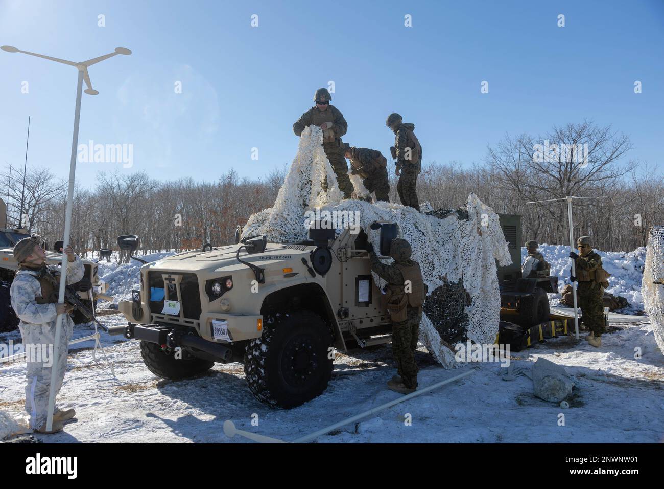 U.S. Marines with 3d Battalion, 12th Marines conceal a Joint Light Tactical Vehicle during Artillery Relocation Training Program 22.4 at the Yausubetsu Maneuver Area, Hokkaido, Japan, Jan. 30, 2023. The skills developed at ARTP increase the proficiency and readiness of the only permanently forward-deployed artillery unit in the Marine Corps, enabling them to provide precision indirect fires. Stock Photo