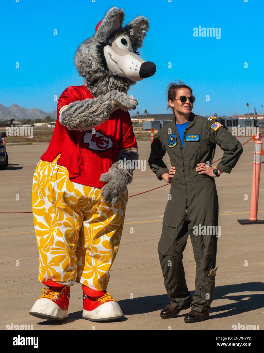 U.S. Navy Lt. Suzelle Thomas, Strike Fighter Squadron (VFA) 192 pilot, listens to KC Wolf, Kansas City Chiefs mascot, Feb. 10, 2023, at Luke Air Force Base, Arizona. Thomas and KC Wolf attended a community relations event at Luke AFB in preparation for the 2023 Super Bowl. Stock Photo