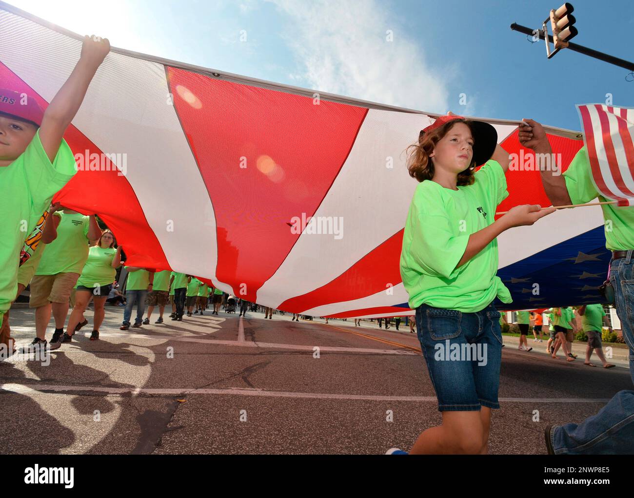 Leah Dittmann, center, right, 10, of Waterford, Erie County, Pa., helps members of Plumbers Local 27 carry a large American flag down State Street during the 5th annual Labor Day parade in downtown Erie, Pa., Monday, Sept. 3, 2018. Dittmann's father Todd, is a member of Local 27, which covers Erie, Pittsburgh and western Pennsylvania. Local 27 was one of 55 units to march in the parade. (Christopher Millette/Erie Times-News via AP) Stock Photo