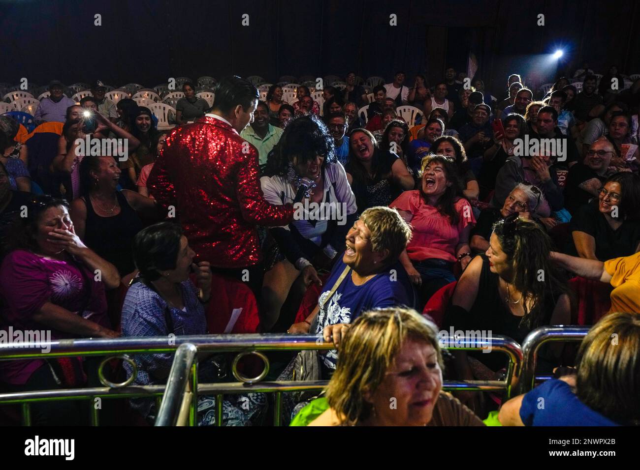 Audience members bust out laughing as Arturo Peña in his role as "La loca  de la cartera", or “The Crazy Purse Lady,” engages with the public during a  Timoteo Circus show, on