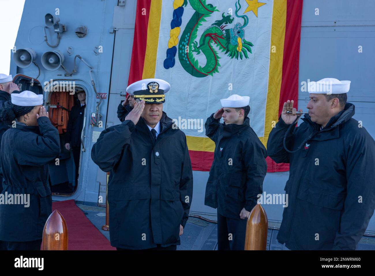 TOKYO BAY, Japan (Jan. 26, 2023) Cmdr. Isaia Infante salutes Sailors as he walks onto the flight deck of the Arleigh Burke-class guided-missile destroyer USS Ralph Johnson (DDG 114) anchored in Tokyo Bay, Japan, prior to a change of command ceremony, Jan. 26. Ralph Johnson is assigned to Commander Task Force 71/Destroyer Squadron 15 forward-deployed to the 7th Fleet area of operation in support of a free and open Indo-Pacific. Stock Photo
