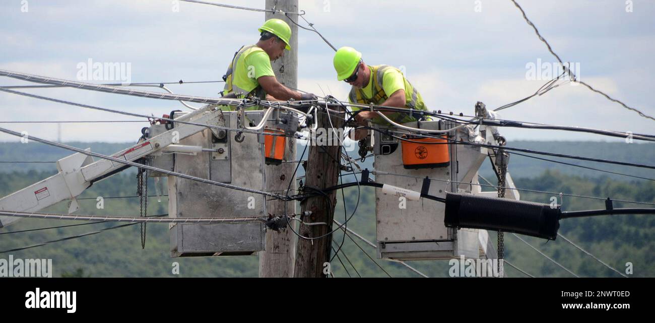 Two workers with Service Electric Cablevision work on cable wires along