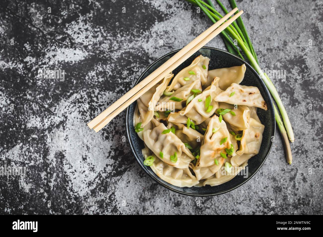 Asian dumplings in bowl, chopsticks, rustic stone background. Top view ... Best dumplings