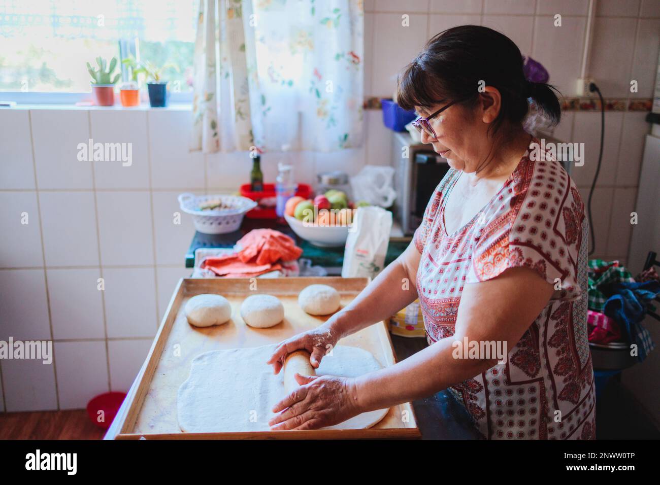 Portrait of an elderly latin woman cooking homemade bread in her kitchen Stock Photo - Alamy