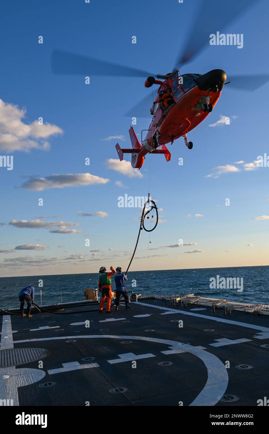 USCGC Stone’s (WMSL 758) crew conducts helicopter training exercises with an Aviation Training Center Mobile instructor and a Coast Guard Helicopter Interdiction Tactical Squadron MH-65 Dolphin helicopter crew in the Atlantic Ocean, Jan. 14, 2023. Stone is on a scheduled multi-mission deployment in the South Atlantic to counter illicit maritime activities and strengthen relationships for maritime sovereignty throughout the region. Stock Photo