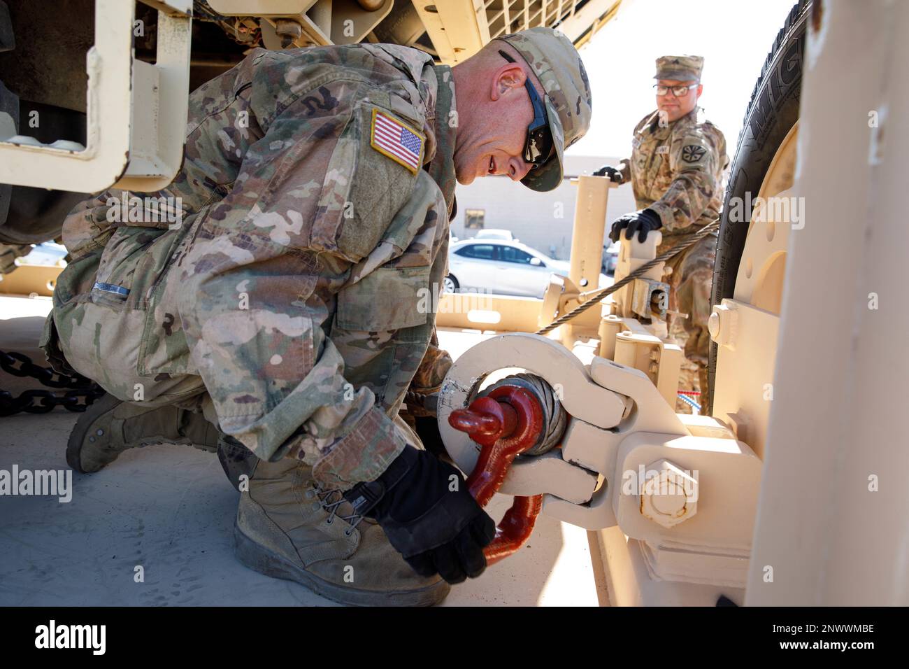 Arizona Army National Guard Sgt. Michael Stearns and Sgt. Kevin Fortier secure a winch cable being used to and an M977 A4 Heavy Expanded Mobility Tactical Truck from a trailer, Feb. 5, 2023, at Papago Park Military Reservation (PPMR) in Phoenix. The two Soldiers, wheeled vehicle mechanics the 3666th Support Maintenance Company, retrieved and transported the HEMTT from Pinal Air Park in Marana using a Modular Catastrophic Recovery System. (Arizona Army National Guard photo by Sgt. 1st Class Brian A. Barbour) Stock Photo