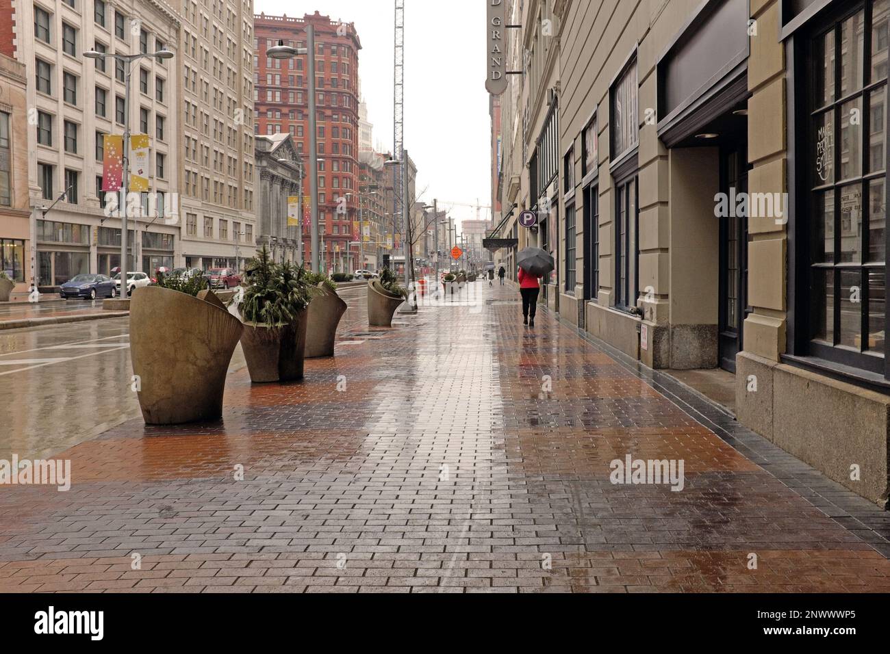 Person walks with umbrella in the rain along Euclid Avenue towards East 9th in downtown Cleveland, Ohio on a rainy February day. Stock Photo