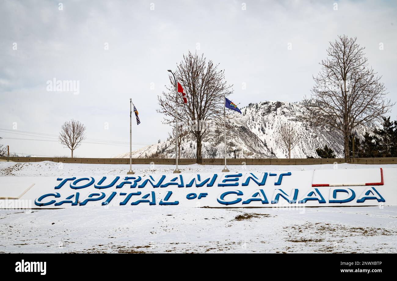 A snow covered 'Tournament Capital of Canada' sign with flags in Kamloops, British Columbia, Canada. The city hosts more than 100 sporting tournaments Stock Photo