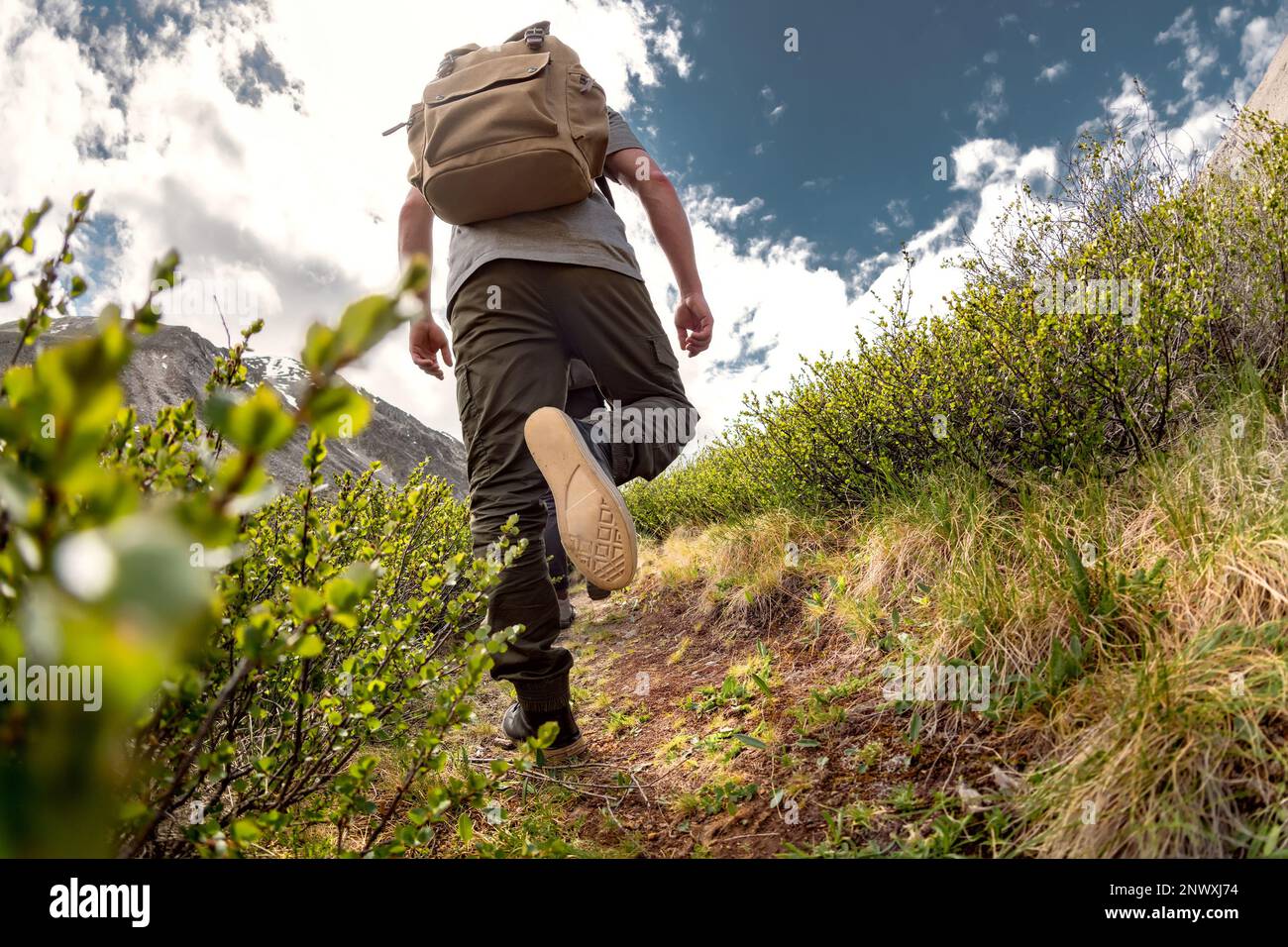 Closeup photo of walking hiker legs on the mountain trail Stock Photo