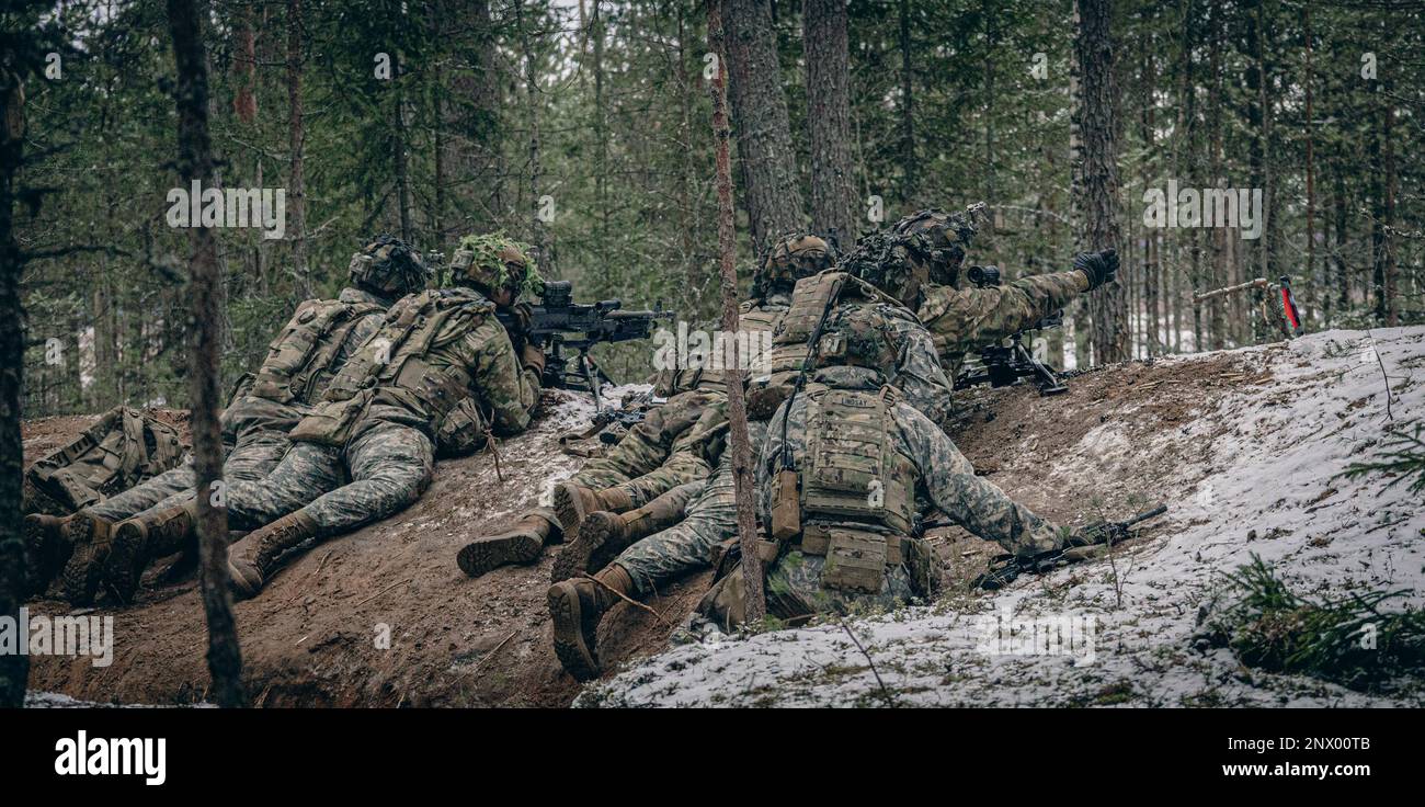 Soldiers with Attack Company, 2nd Brigade Combat Team, 101st Airborne Division lay prone during a react-to-contact exercise on camp Tapa, Estonia, Feb. 4, 2023. The training aimed to display combat credibility and lethal forces to deter aggression and build readiness in the Estonian Defense Force. Stock Photo