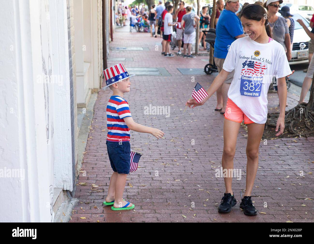 Camden Grainger, 4, of Fredericksburg, hands a flag to Arielle Garay of Dumfries before the