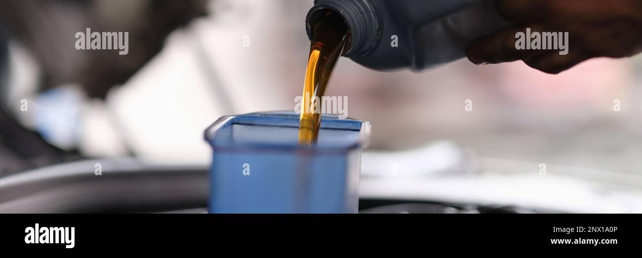 Mechanic pouring engine oil into engine in car service Stock Photo Alamy