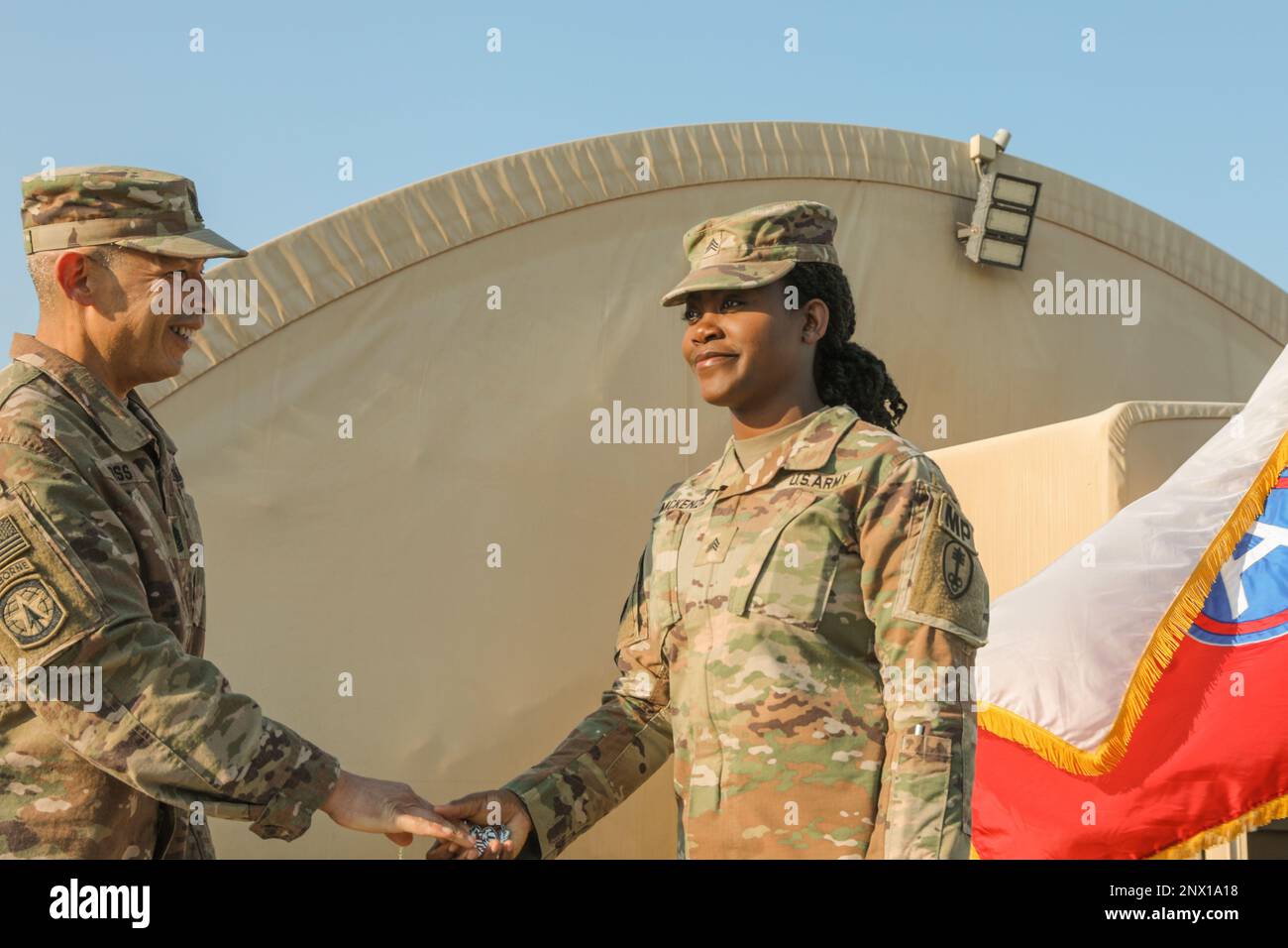 U.S. Army Sgt. Shakeria McKenzie with the 300th Military Police Brigade, receives a challenge coin from Command Sgt. Maj. Curtis Moss, command sergeant major for the 369th Sustainment brigade, during an Equal Opportunity Leaders Course graduation ceremony held on Camp Arifjan, Kuwait, Jan. 28, 2023. Stock Photo