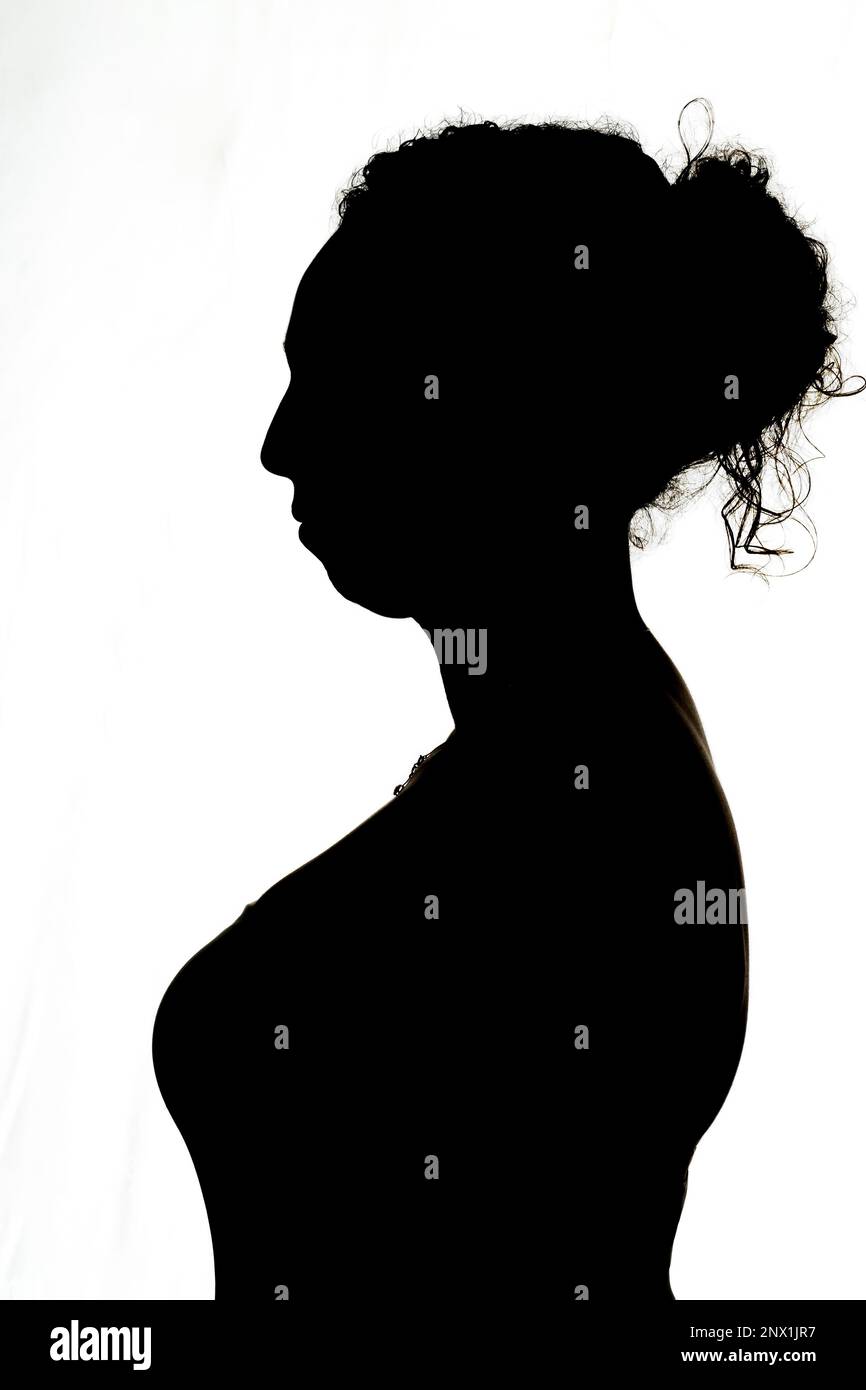 silhouette of young brunette woman in profile backlight Stock Photo