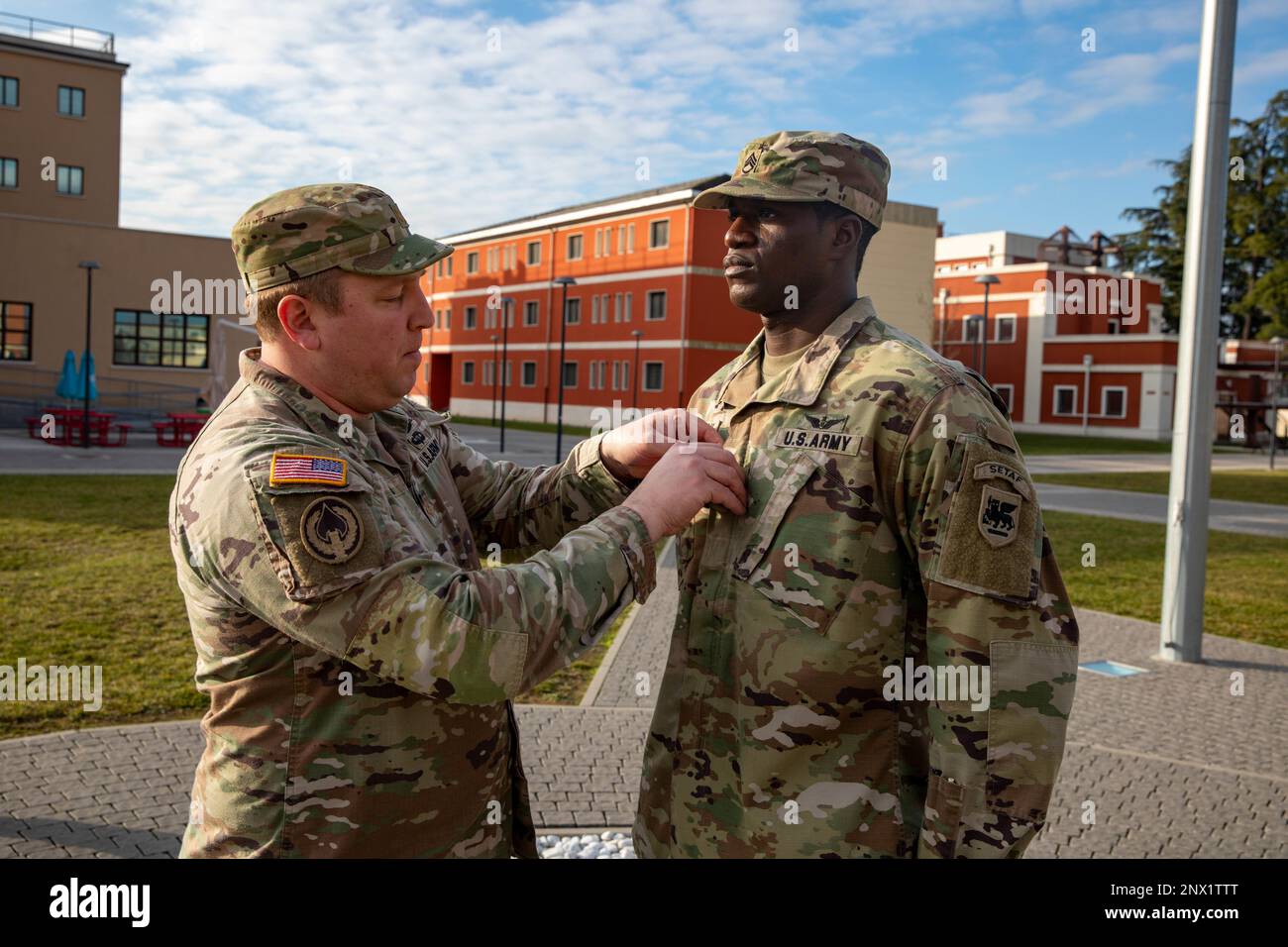 U.S. Army Maj. Matthew James with U.S. Army Southern European Task Force, Africa (SETAF-AF) G3, promotes Staff Sgt. Chief Nuamah to Sgt. 1st Class on Caserma Del Din, Vicenza, Italy, Jan. 27, 2023. Nuamah’s promotion to the senior rank of Sgt. 1st class is a result of the hard work and dedication he provides to SETAF-AF’s G3 and the Army as a whole. Stock Photo
