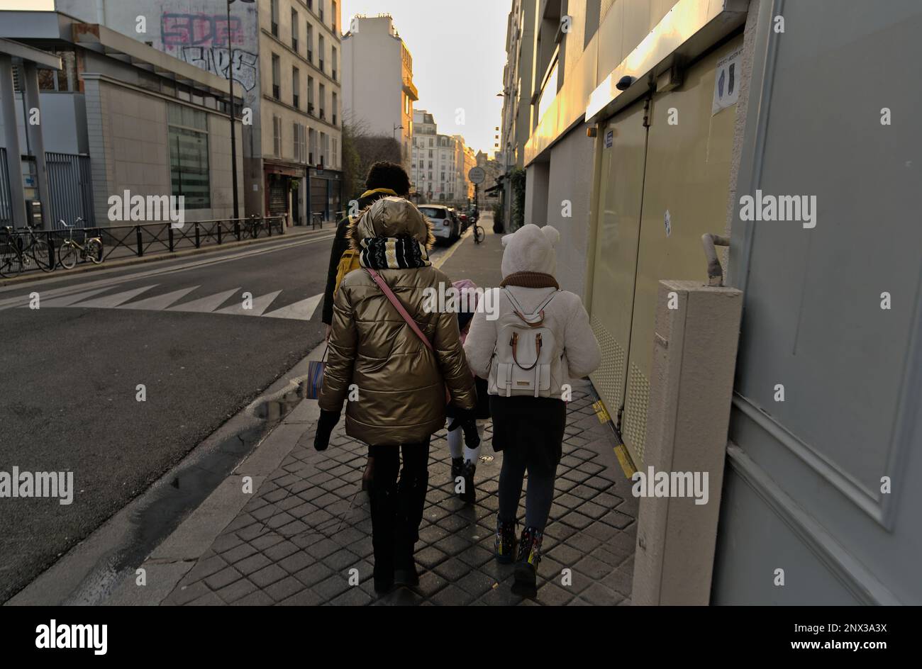 Family of 4 walking the streets of Paris in the morning. First beams of sunlight Stock Photo